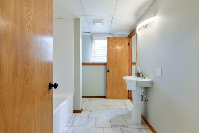 bathroom with a bath and a drop ceiling