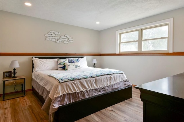 bedroom featuring light hardwood / wood-style floors and a textured ceiling