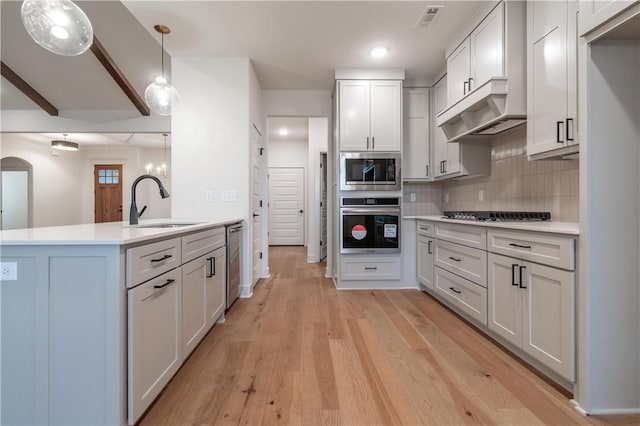 256 Fiori St, Springdale, AR 72762 - kitchen featuring stainless steel appliances, light countertops, tasteful backsplash, light wood-type flooring, and pendant lighting