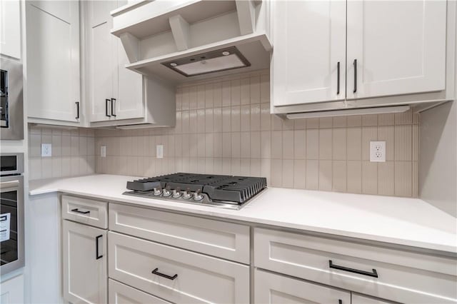 256 Fiori St, Springdale, AR 72762 - kitchen with appliances with stainless steel finishes, decorative backsplash, light countertops, wall chimney exhaust hood, and white cabinetry