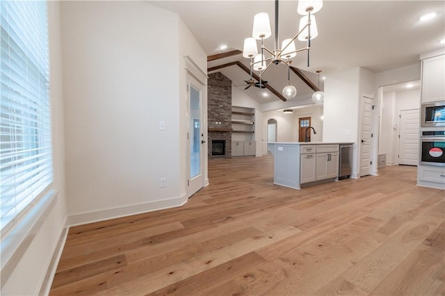 256 Fiori St, Springdale, AR 72762 - kitchen featuring open floor plan, appliances with stainless steel finishes, a chandelier, light wood-style floors, and lofted ceiling
