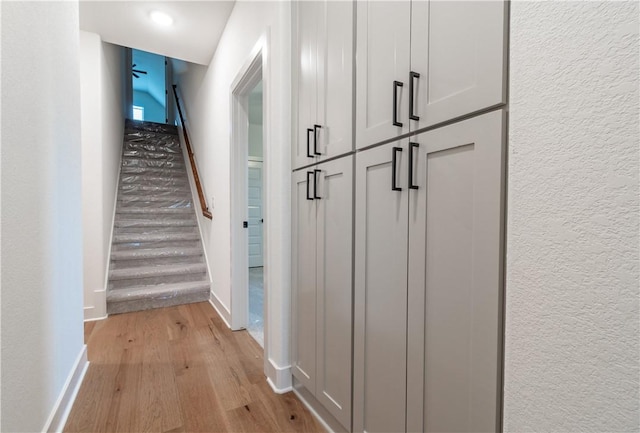 256 Fiori St, Springdale, AR 72762 - hallway with light wood-type flooring, a textured wall, and stairs