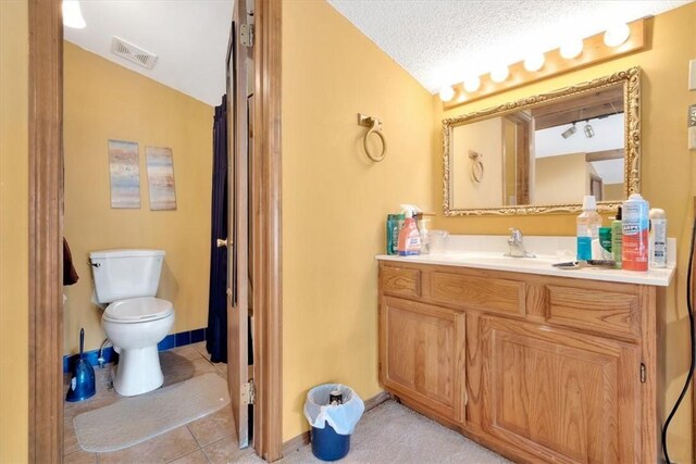 bathroom featuring tile patterned floors, a textured ceiling, vaulted ceiling, toilet, and vanity