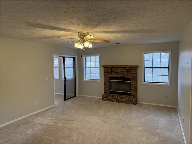 unfurnished living room with ceiling fan, a fireplace, and light colored carpet