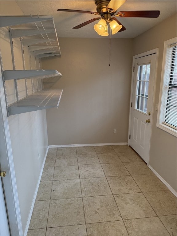 entryway with ceiling fan and light tile patterned floors