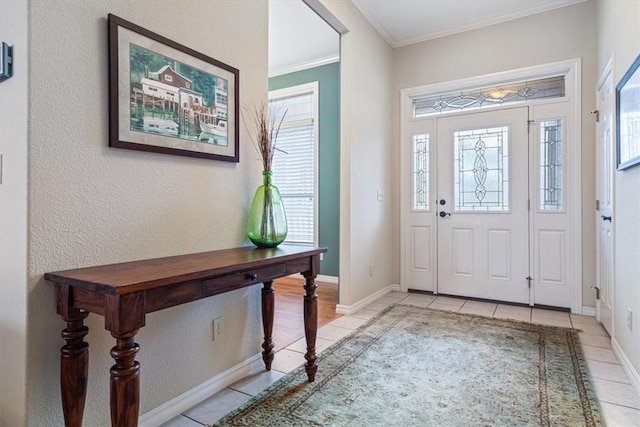 entryway with a healthy amount of sunlight, ornamental molding, and light tile patterned floors