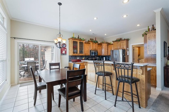 tiled dining room with a notable chandelier and ornamental molding