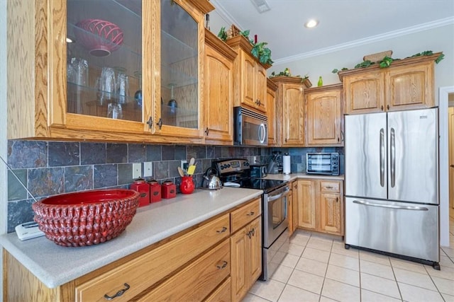 kitchen with decorative backsplash, appliances with stainless steel finishes, light tile patterned floors, and crown molding