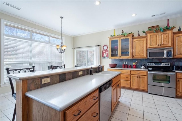 kitchen featuring backsplash, ornamental molding, stainless steel appliances, a chandelier, and a breakfast bar area