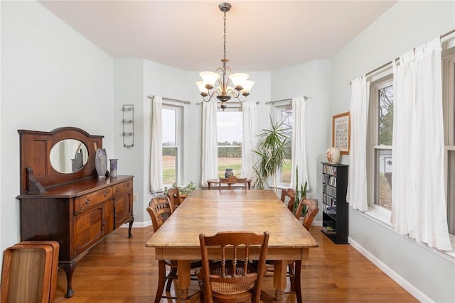 dining room featuring hardwood / wood-style floors and an inviting chandelier