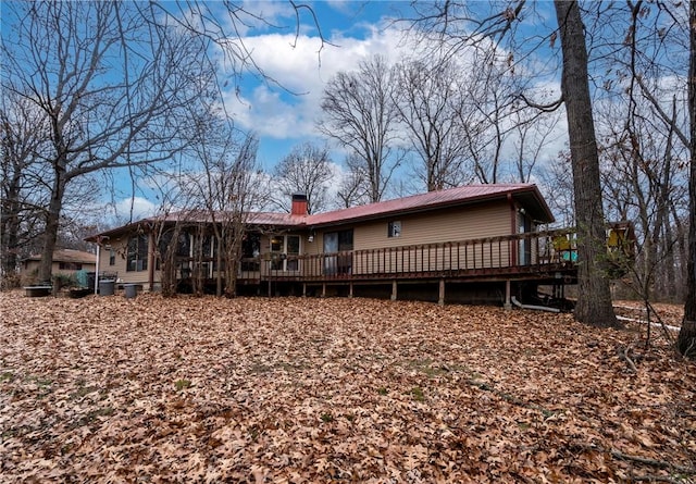 rear view of house featuring a wooden deck