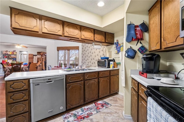 kitchen with ceiling fan, dishwasher, sink, kitchen peninsula, and a textured ceiling