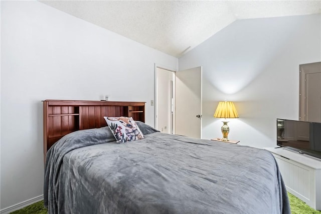 bedroom with a textured ceiling and lofted ceiling