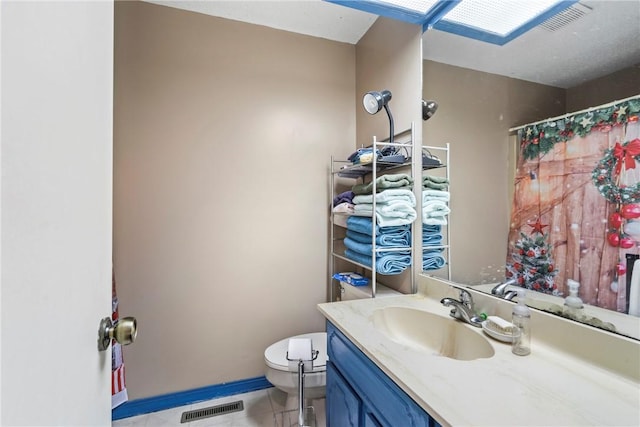 bathroom featuring tile patterned flooring, vanity, and toilet