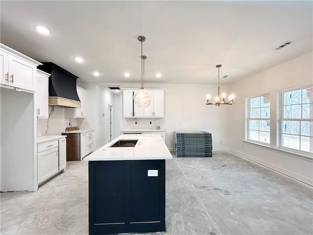 kitchen with white cabinetry, custom range hood, and decorative light fixtures