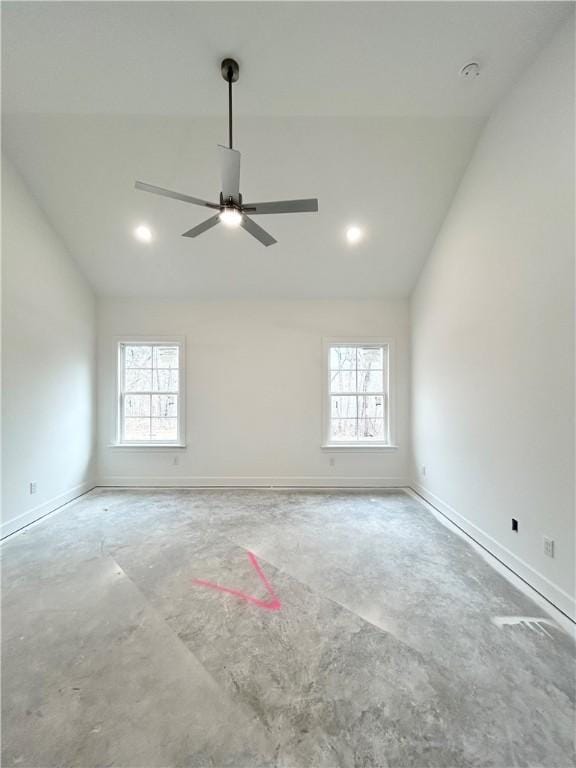 empty room featuring vaulted ceiling, ceiling fan, and a healthy amount of sunlight