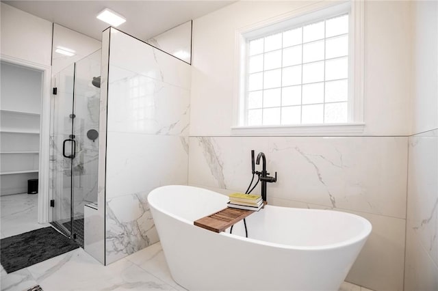 bathroom featuring tile walls and shower with separate bathtub