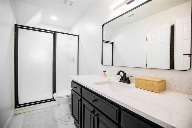 bathroom featuring vanity, toilet, and a shower with door