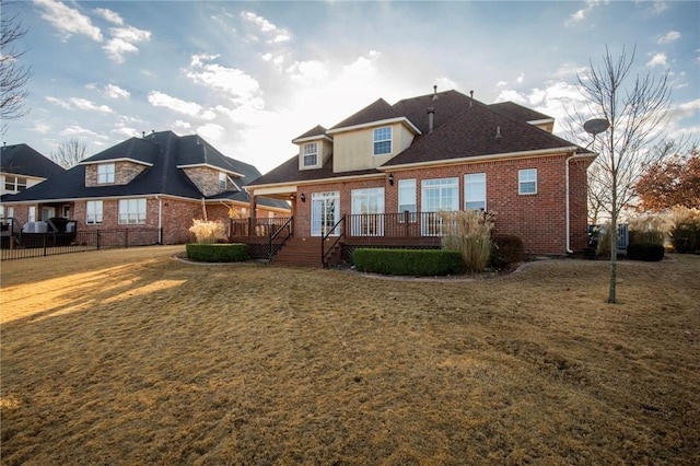 back of property featuring a yard and a wooden deck