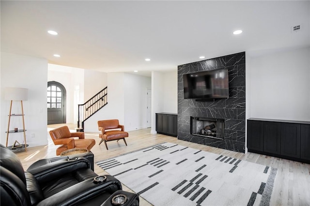 living room with light wood-type flooring and a fireplace