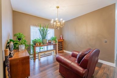 sitting room with wood-type flooring and a chandelier