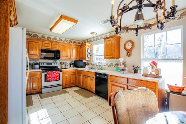 kitchen featuring light tile patterned floors, sink, and black appliances