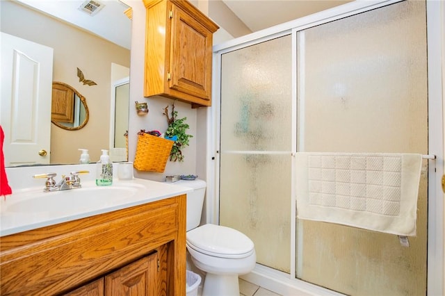 bathroom featuring tile patterned floors, vanity, toilet, and a shower with shower door