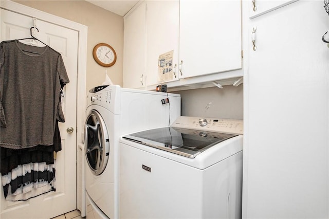 laundry area with light tile patterned flooring, cabinets, and independent washer and dryer