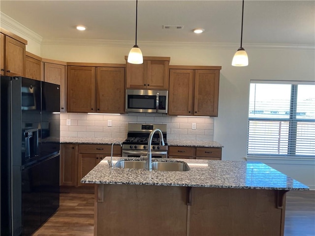 kitchen with dark hardwood / wood-style flooring, light stone countertops, hanging light fixtures, and stainless steel appliances