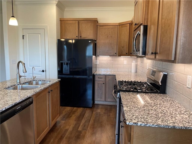 kitchen with light stone counters, appliances with stainless steel finishes, dark wood-type flooring, ornamental molding, and a sink