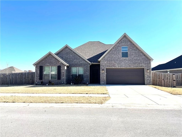 view of front of home featuring concrete driveway, brick siding, a front yard, and fence