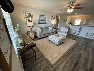 living room with ceiling fan and dark hardwood / wood-style flooring