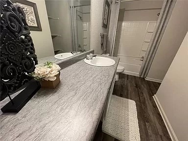 full bathroom featuring shower / washtub combination, vanity, wood-type flooring, and toilet