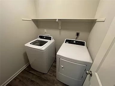 laundry area featuring washing machine and dryer and dark hardwood / wood-style floors