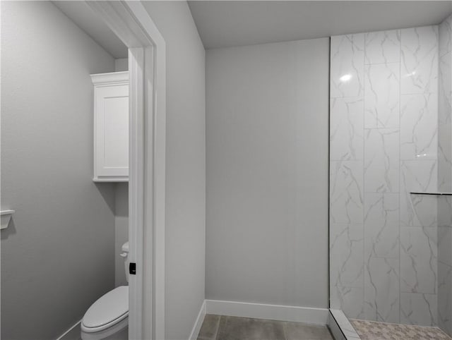 bathroom with tiled shower and toilet