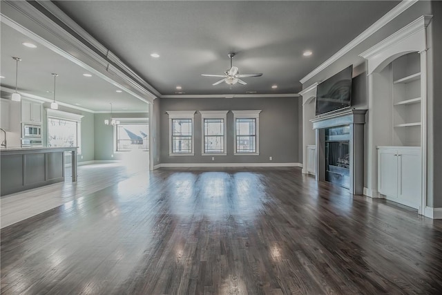 unfurnished living room featuring dark hardwood / wood-style flooring, plenty of natural light, and ornamental molding