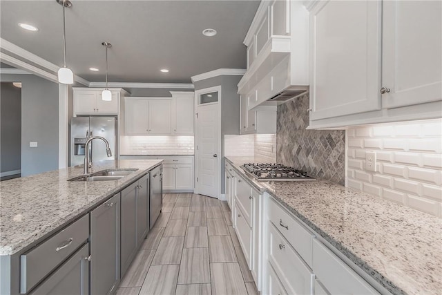 kitchen featuring white cabinetry, custom range hood, and an island with sink