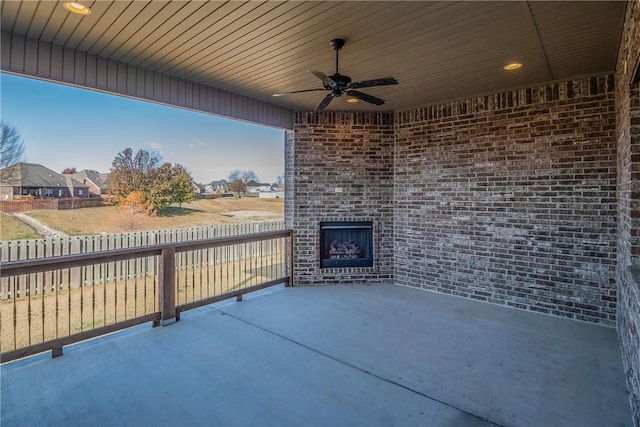 view of patio / terrace featuring an outdoor brick fireplace and ceiling fan