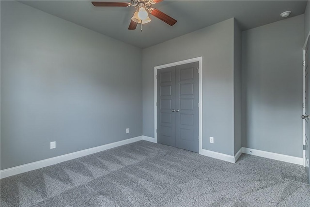 unfurnished bedroom with ceiling fan, a closet, and carpet