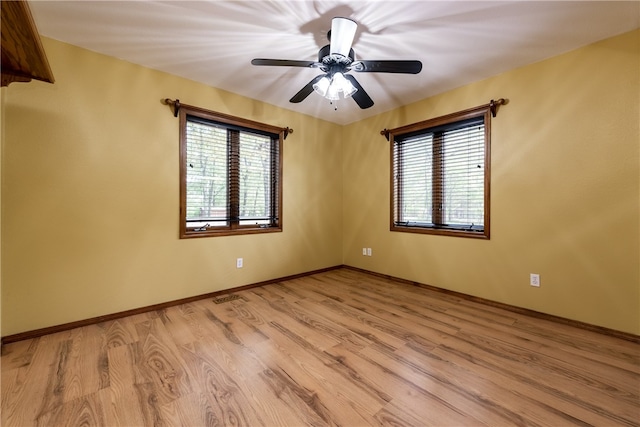 empty room with ceiling fan and light hardwood / wood-style floors