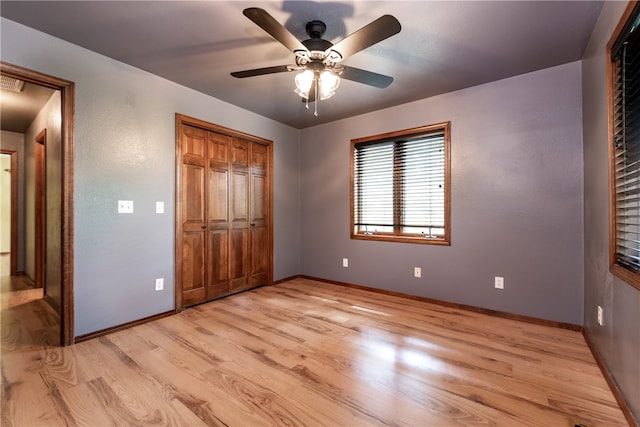 unfurnished bedroom featuring ceiling fan, a closet, and light hardwood / wood-style flooring