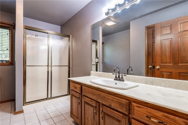 bathroom with tile patterned flooring, vanity, and a shower with shower door