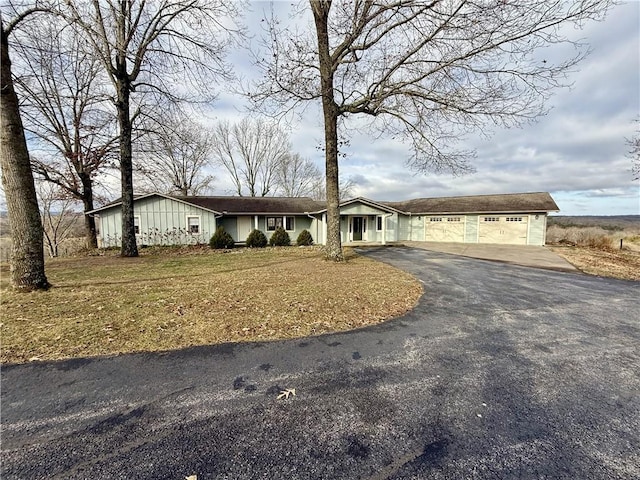 ranch-style house with a garage and a front lawn