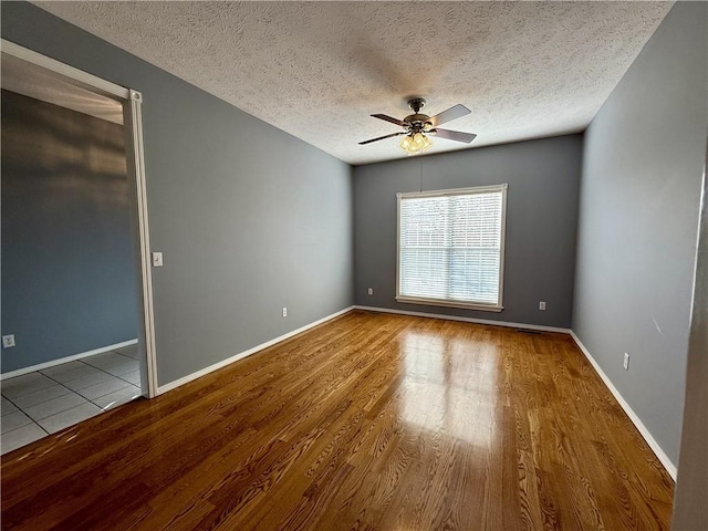 spare room featuring ceiling fan, a textured ceiling, and light hardwood / wood-style flooring