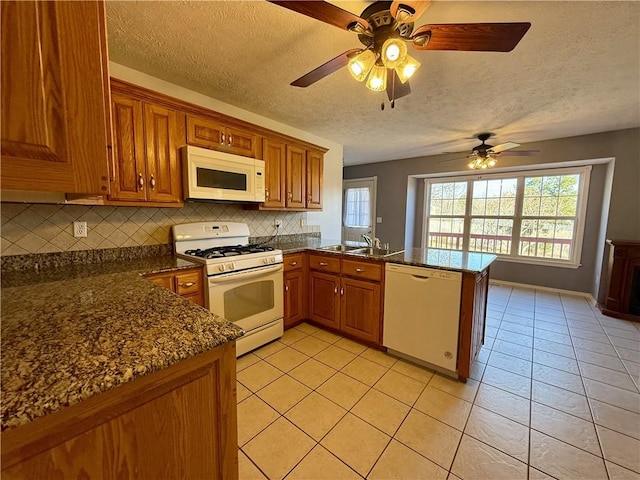 kitchen featuring sink, kitchen peninsula, white appliances, decorative backsplash, and light tile patterned flooring