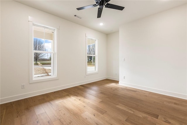 unfurnished room with light wood-type flooring, a wealth of natural light, and baseboards