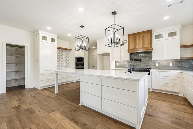 kitchen featuring open shelves, light countertops, dark wood-type flooring, a sink, and built in microwave