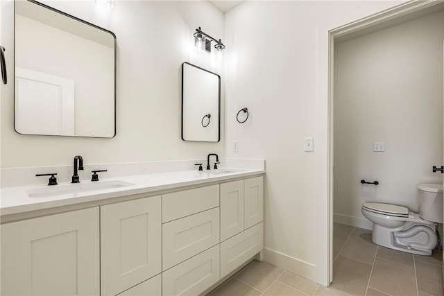 bathroom featuring tile patterned flooring, baseboards, a sink, and toilet