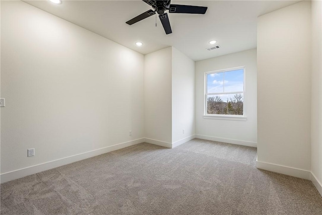 spare room with recessed lighting, carpet flooring, visible vents, and baseboards