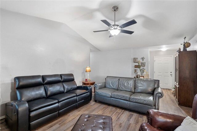 living room featuring ceiling fan, light wood-type flooring, and lofted ceiling